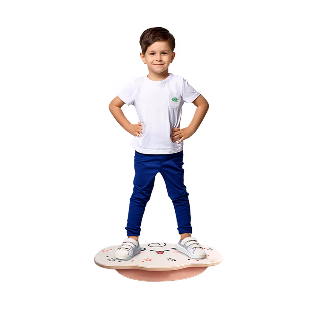 Smiling boy with hands on hips standing on a balance board with cartoon designs.