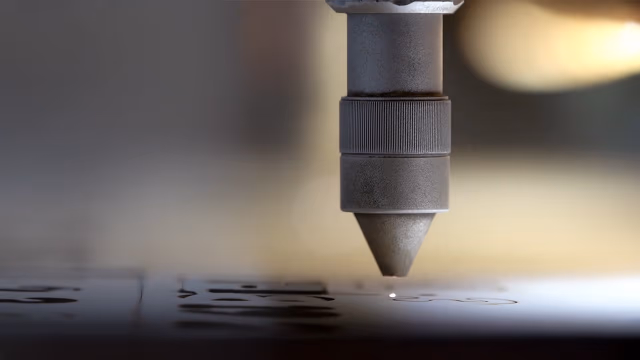 Close-up of a laser engraving machine etching a design onto a flat surface.